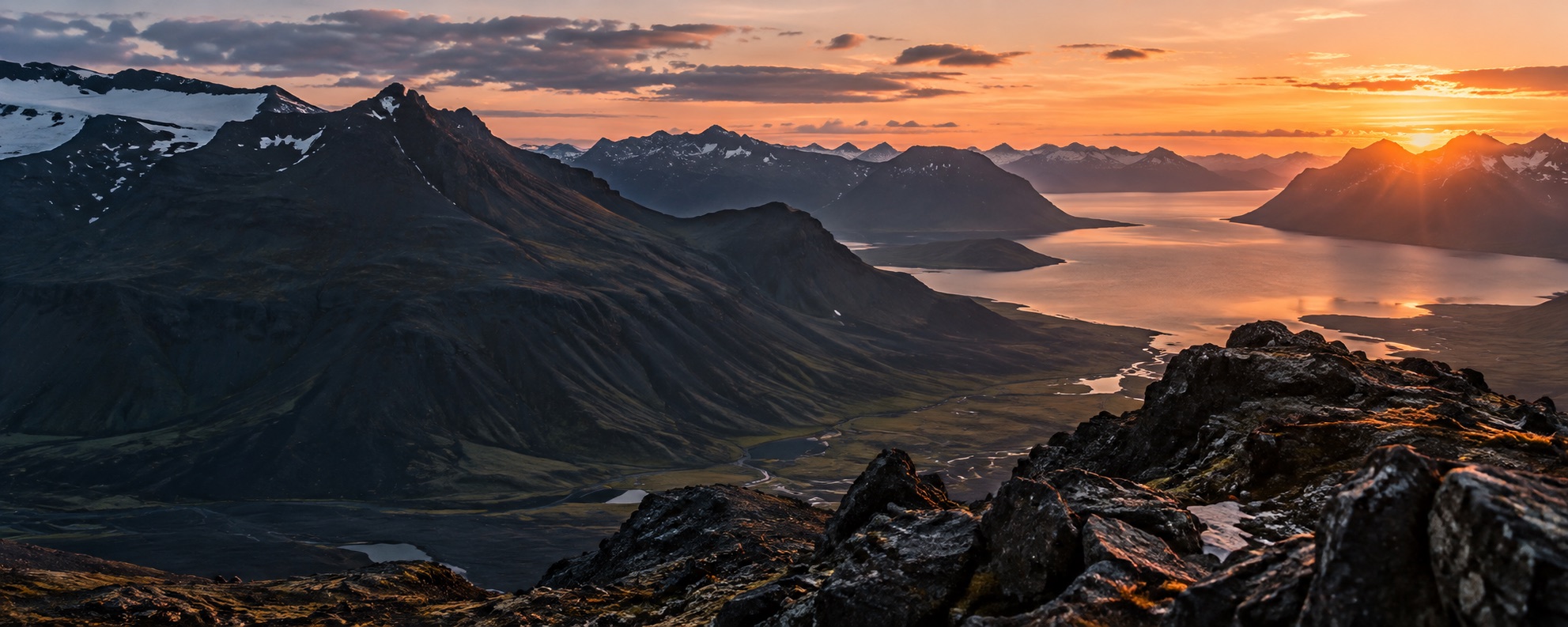 Fjallatindar og fjörður í hlýju kvöldljósi